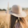 woman wearing beige sun hat standing on wheat field