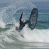 man in black wet suit riding on black surfboard during daytime