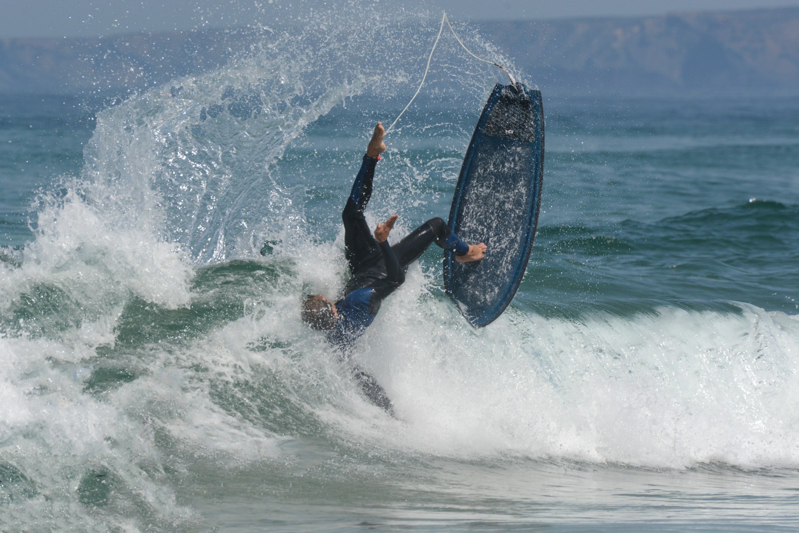 man in black wet suit riding on black surfboard during daytime