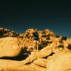 A person stands on a rocky desert landscape.