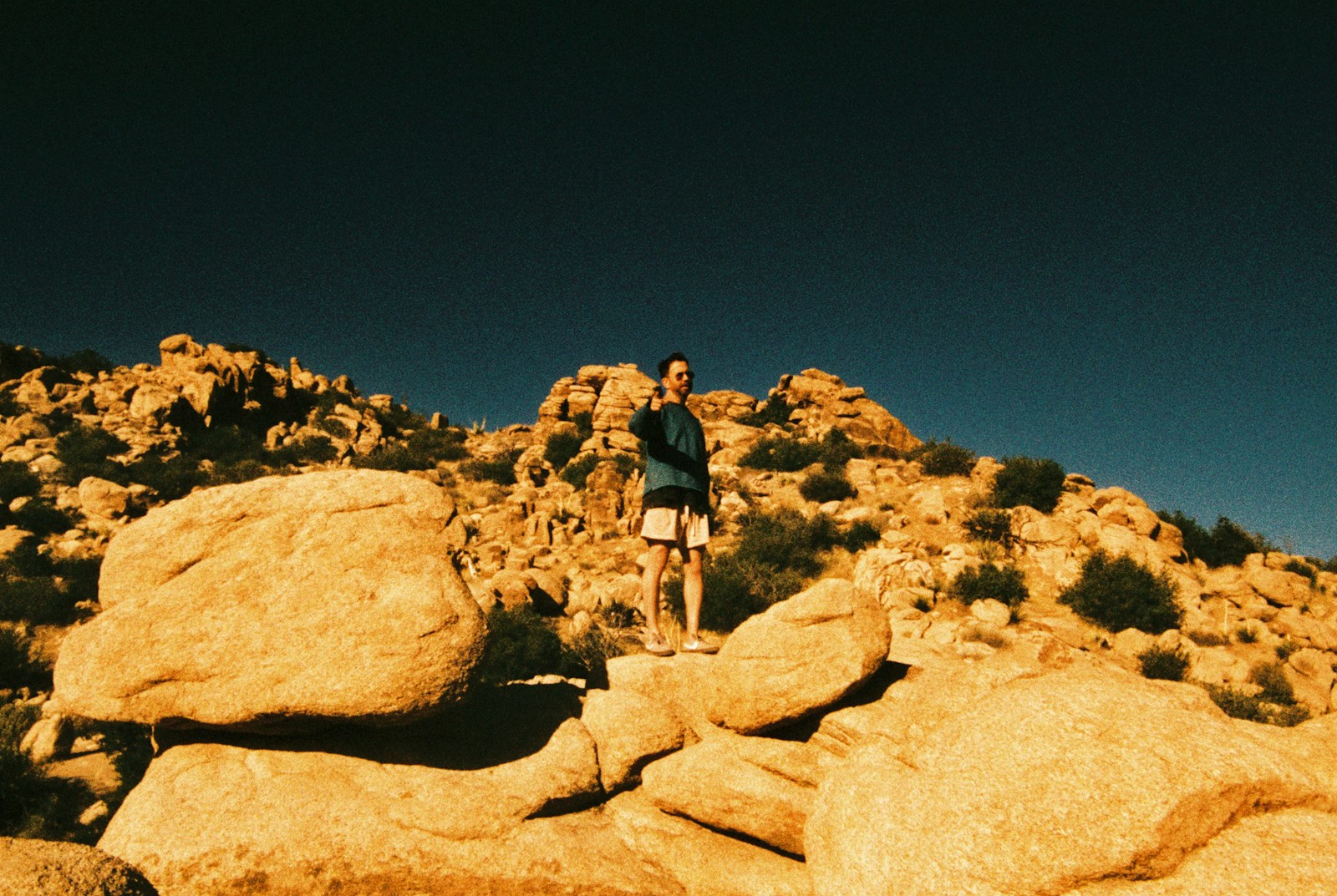 A person stands on a rocky desert landscape.